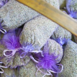 Long purple see through bags filled with a multitude of herbs and flowers sit in a basket