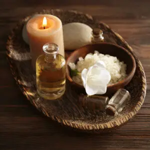 Spa set with sea salt, exotic flowers and candles on wicker tray