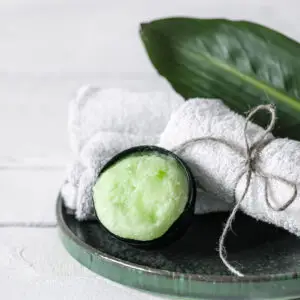Green soap, green leaf and twine wrapped towel in a shower setting