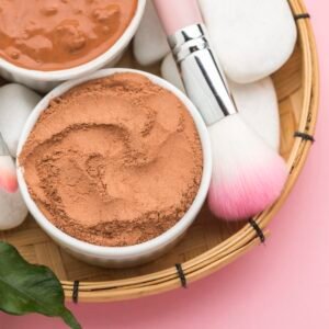 Creamy brown paste in white ceramic bowls with makeup applicators